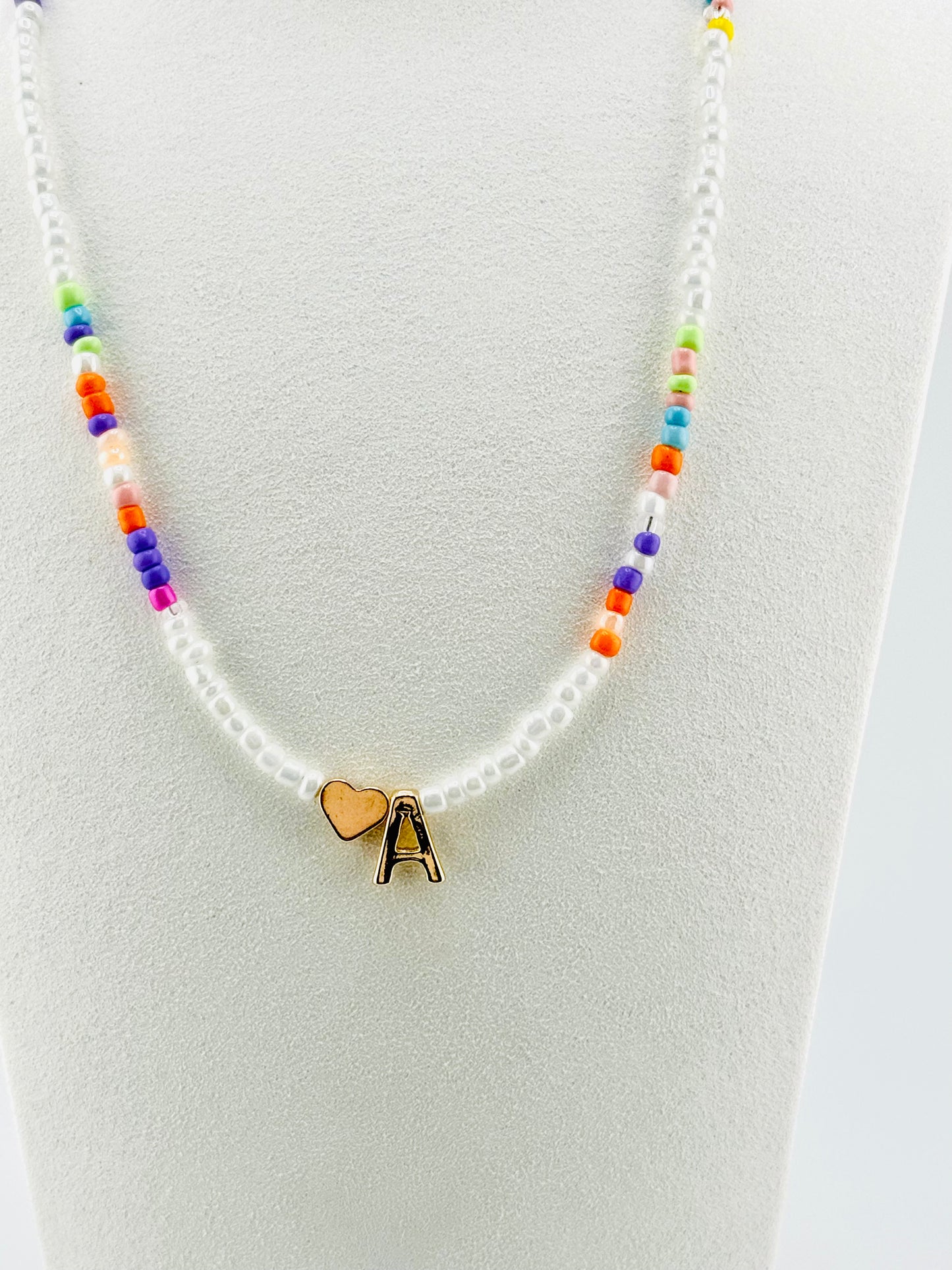 A beaded Initial necklace in white and pastel colors