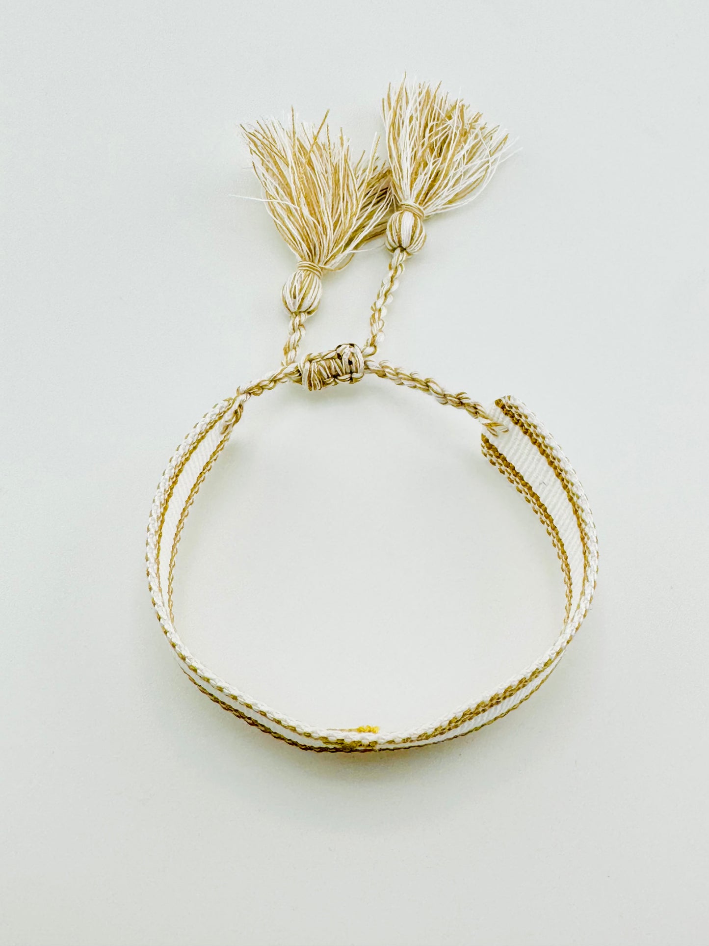 Cross woven bracelet in gold and white thread