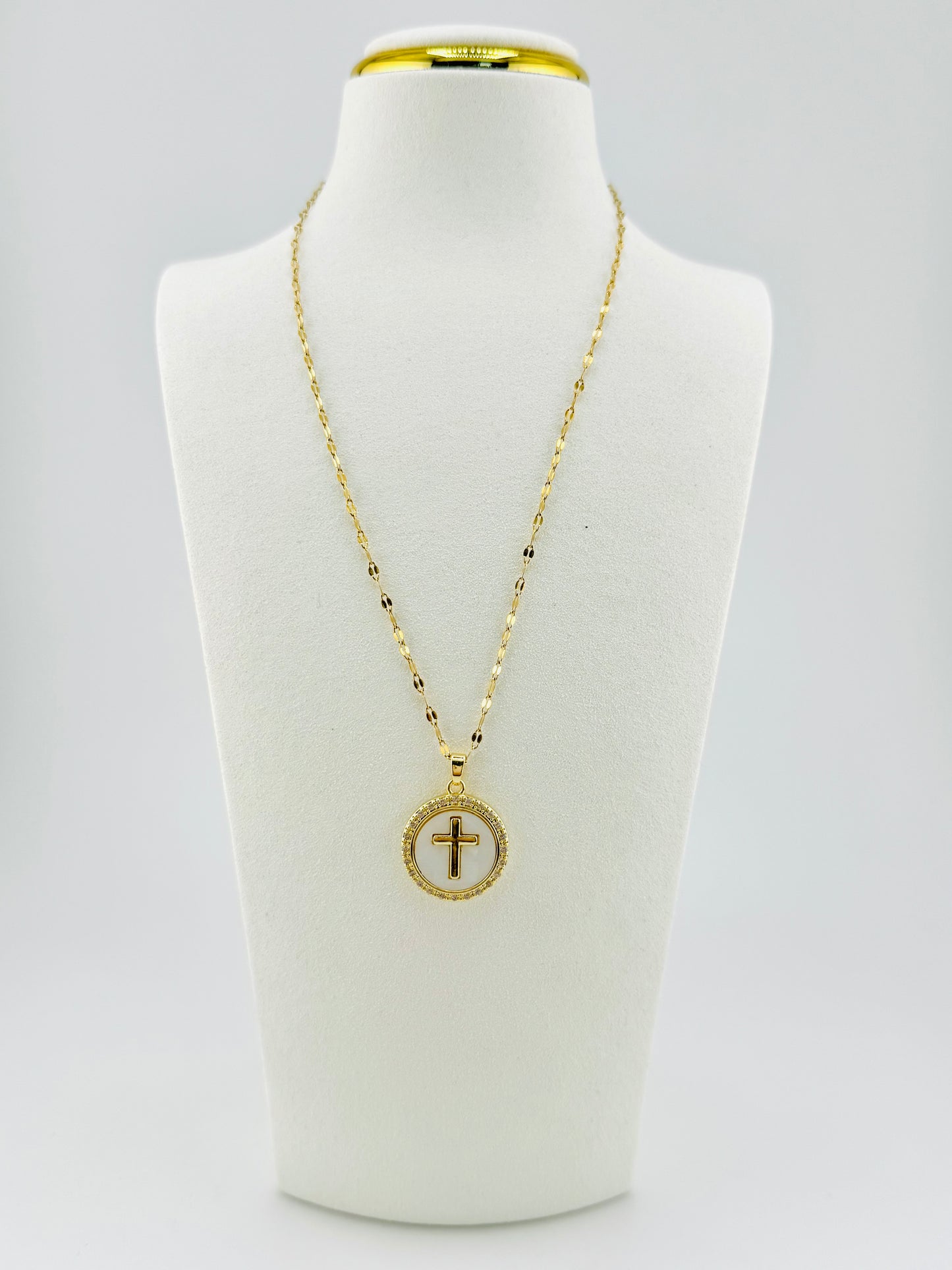 Front view of 18K gold-filled mother of pearl cross necklace on white display