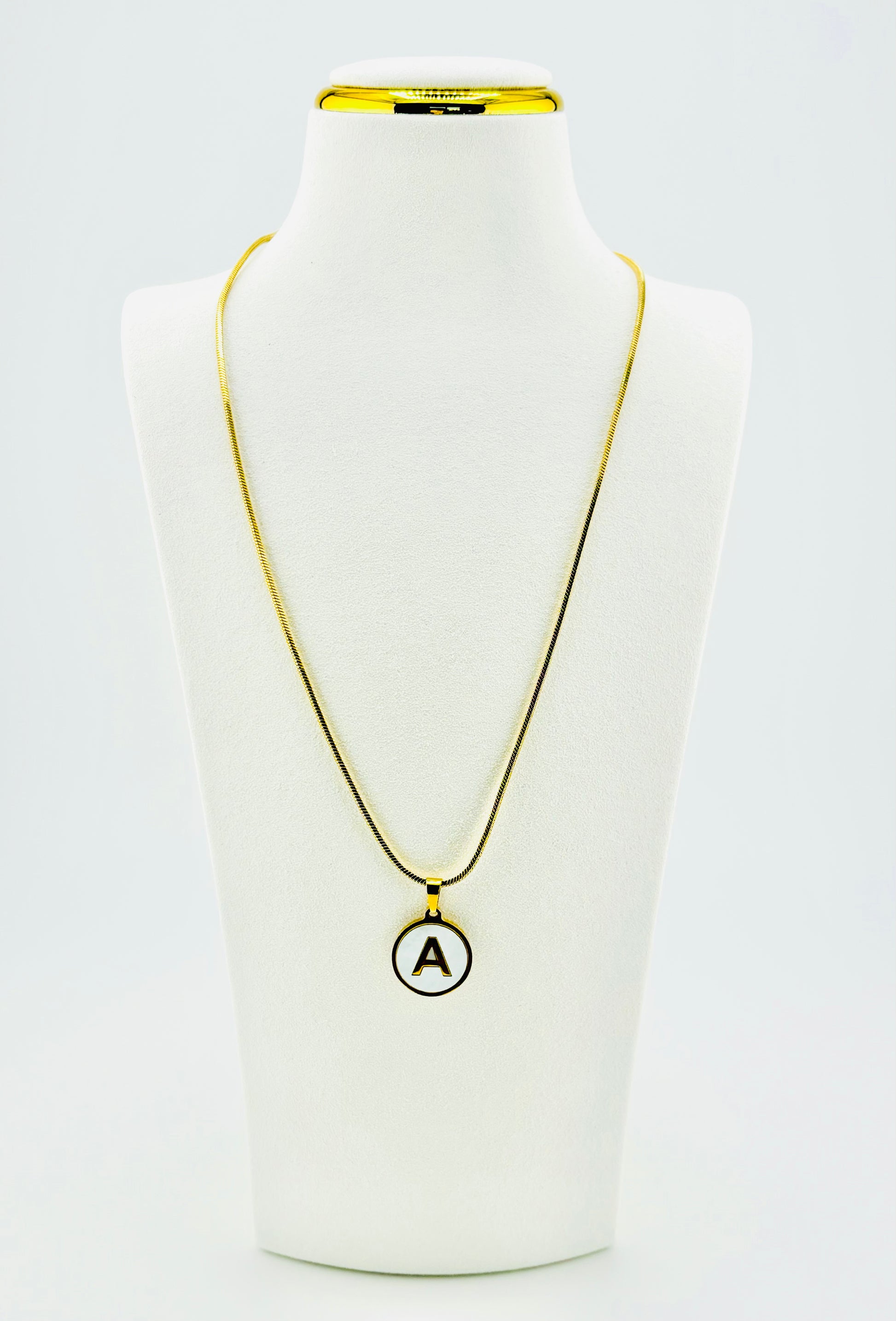 Round mother-of-pearl letter A pendant necklace with polished gold-tone chain